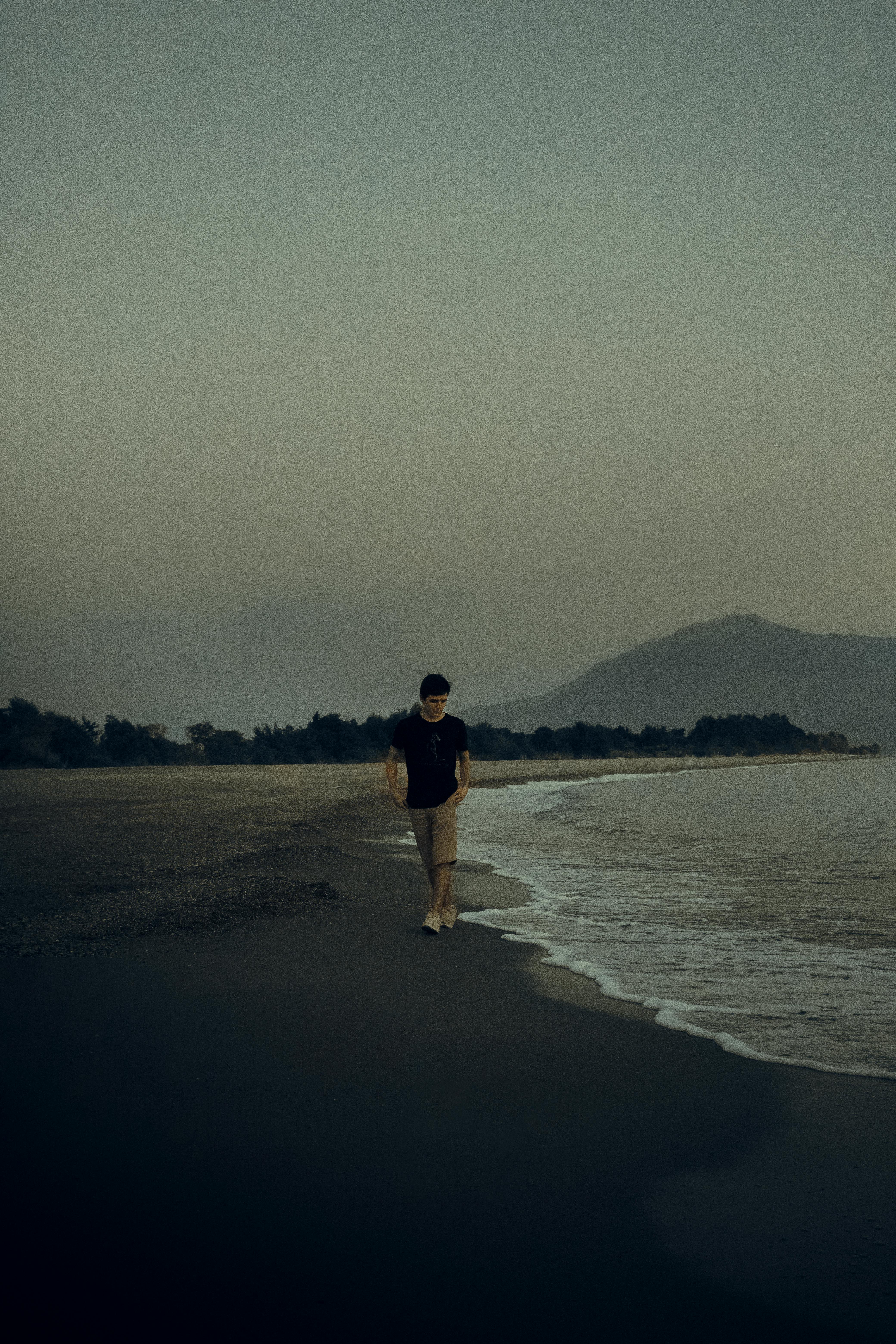 Candid scene of a student alone at dusk, phone glow on face